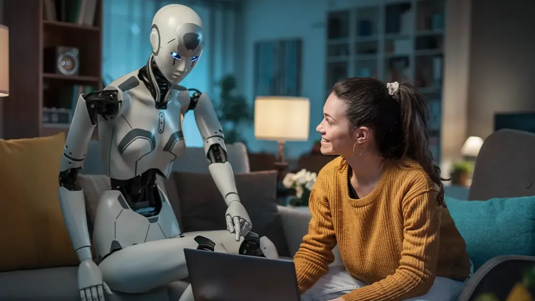 KI als Roboter neben Frau an Laptop dargestellt
