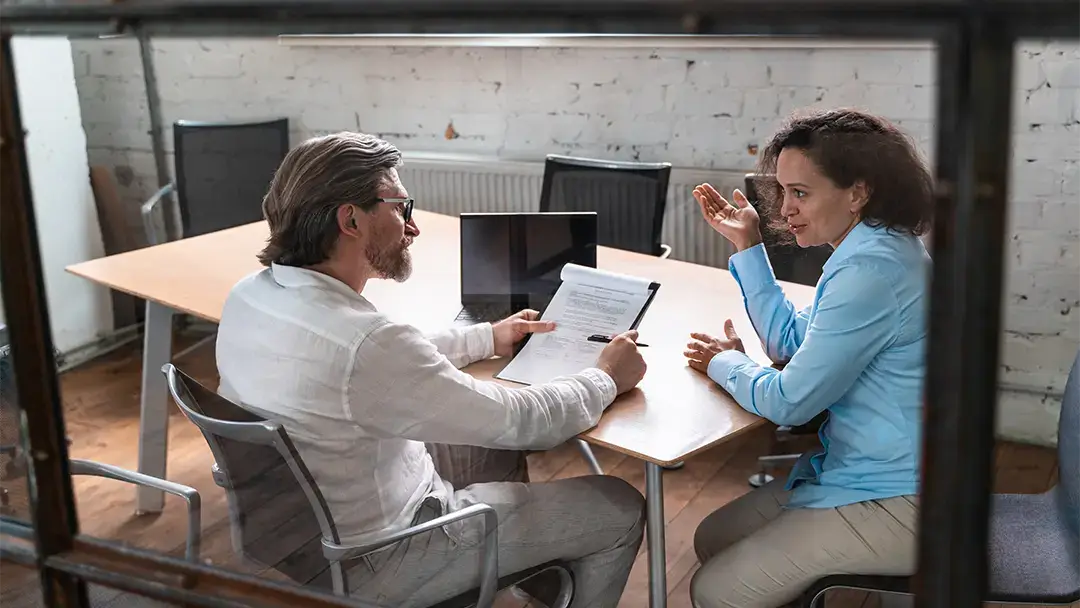 Zwei Personen im Bewerbungsgespräch an einem Tisch