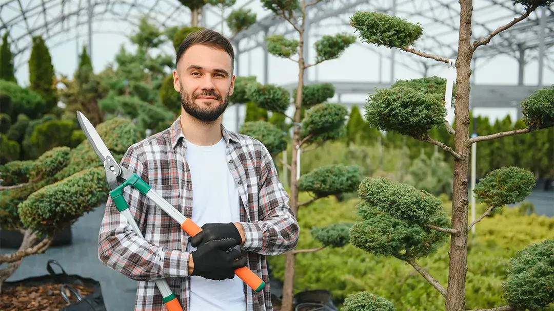 Selbständiger Landschaftsgärtner Stefan mit Heckenschere in der Hand